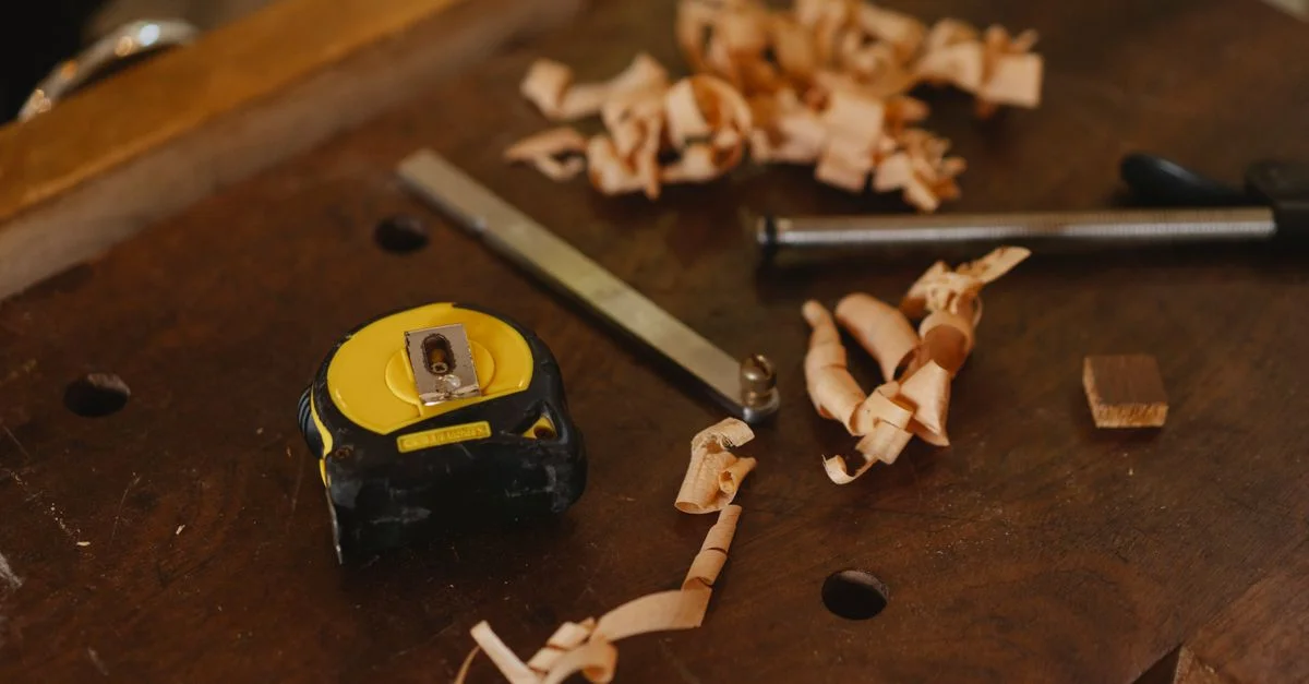 Vue détaillée des outils de menuiserie et des copeaux de bois sur un établi en bois, mettant en valeur l'artisanat.