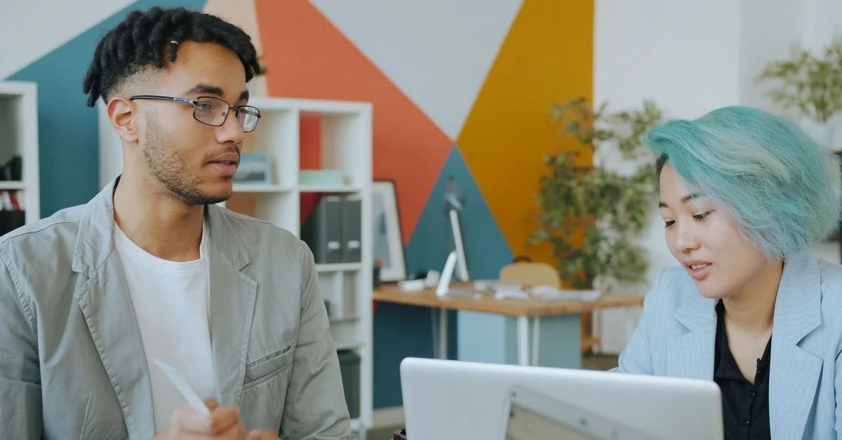 Deux collègues discutaient dans un espace de bureau moderne.